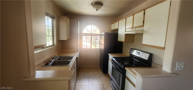 kitchen featuring light tile floors, white cabinetry, sink, and range