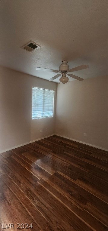 empty room featuring dark wood-type flooring and ceiling fan