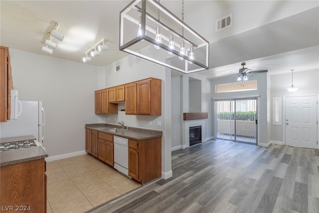 kitchen with ceiling fan, white appliances, a high ceiling, rail lighting, and hanging light fixtures