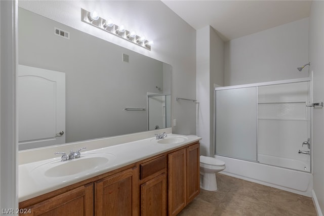 full bathroom with tile flooring, double sink, toilet, enclosed tub / shower combo, and oversized vanity