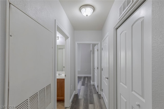 corridor with hardwood / wood-style flooring