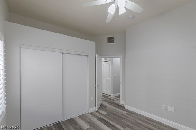 unfurnished bedroom with hardwood / wood-style flooring, a closet, and ceiling fan