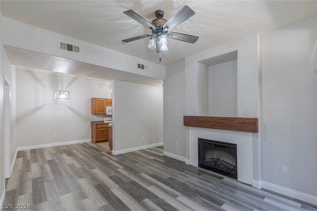 unfurnished living room with ceiling fan and hardwood / wood-style flooring