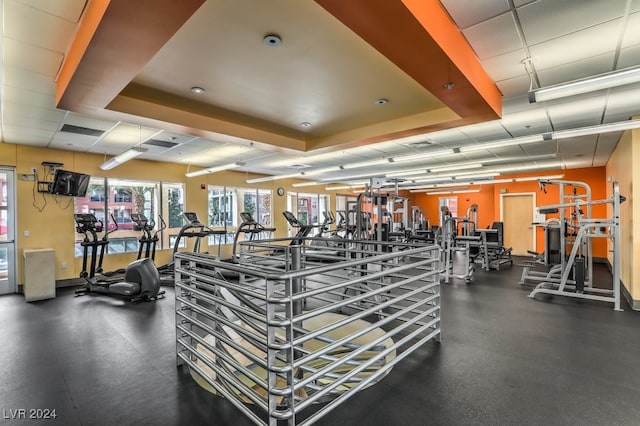 workout area featuring a tray ceiling