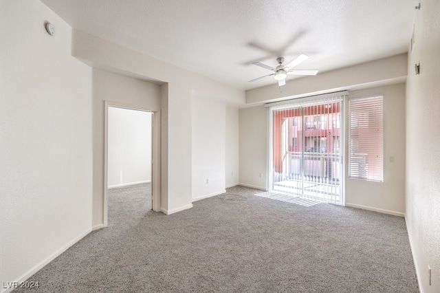 carpeted spare room featuring ceiling fan