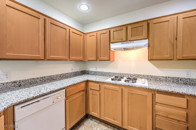 kitchen featuring white appliances and light stone countertops