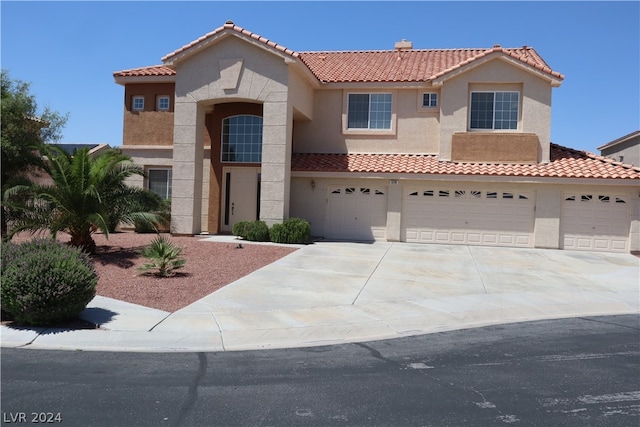 mediterranean / spanish home featuring a garage