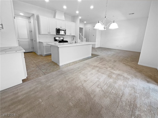 kitchen with decorative light fixtures, a notable chandelier, appliances with stainless steel finishes, light colored carpet, and white cabinets