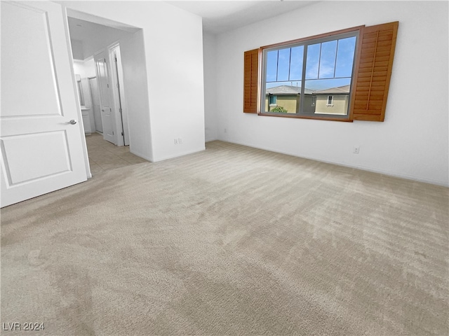 unfurnished room featuring light colored carpet