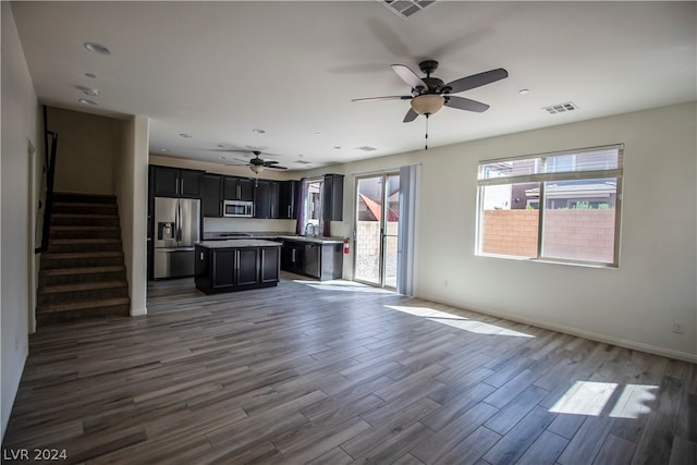 unfurnished living room featuring ceiling fan, sink, and hardwood / wood-style flooring