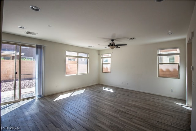 empty room featuring dark wood-type flooring, plenty of natural light, and ceiling fan