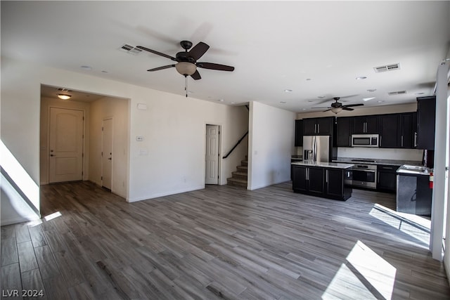 kitchen featuring ceiling fan, stainless steel appliances, light hardwood / wood-style flooring, and a kitchen island