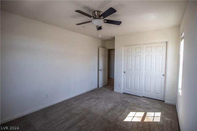 unfurnished bedroom with a closet, dark colored carpet, and ceiling fan