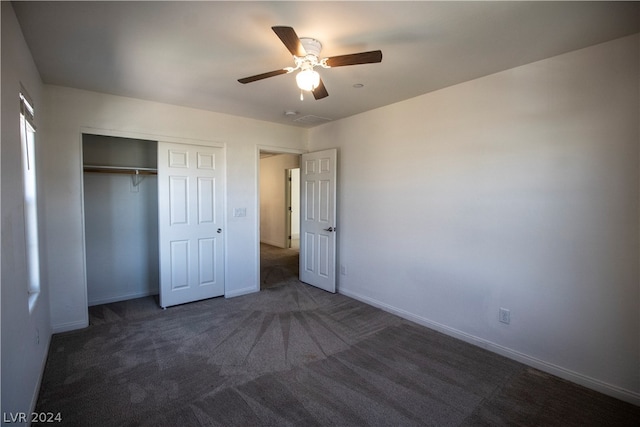 unfurnished bedroom with a closet, ceiling fan, and dark carpet