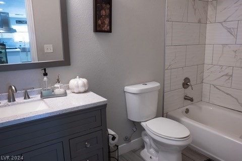 full bathroom with tiled shower / bath combo, vanity, and toilet