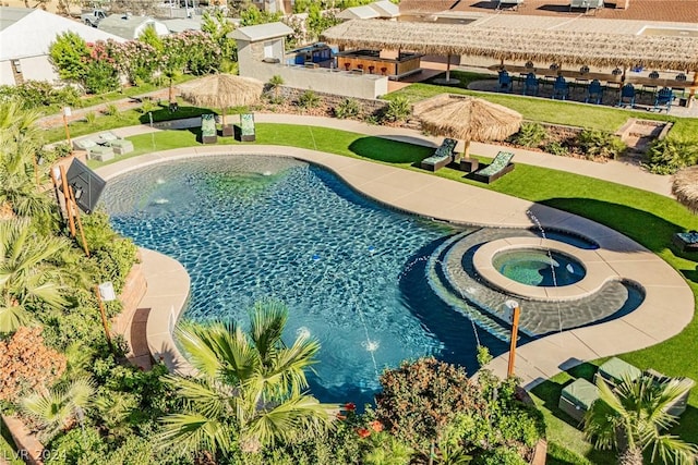 view of pool featuring a lawn and an in ground hot tub