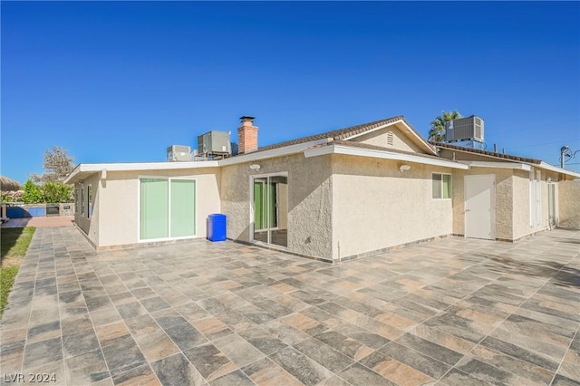 rear view of house featuring a patio and cooling unit