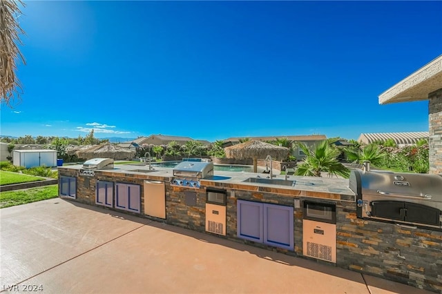 view of patio / terrace featuring exterior kitchen, sink, and grilling area