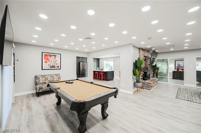 playroom featuring light hardwood / wood-style floors, a brick fireplace, a wealth of natural light, and pool table