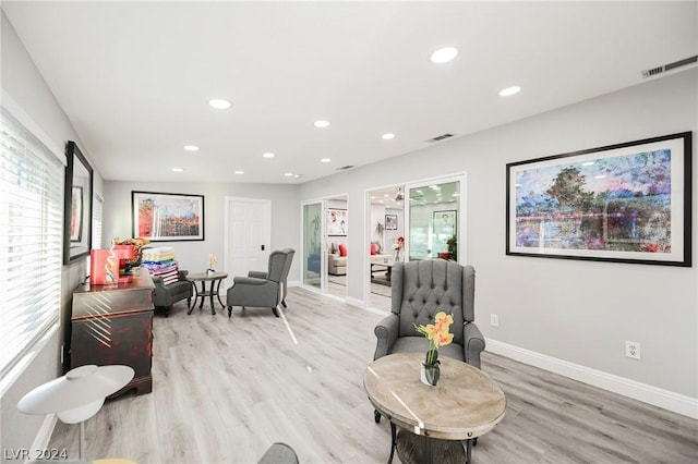 living area featuring ceiling fan and light hardwood / wood-style flooring