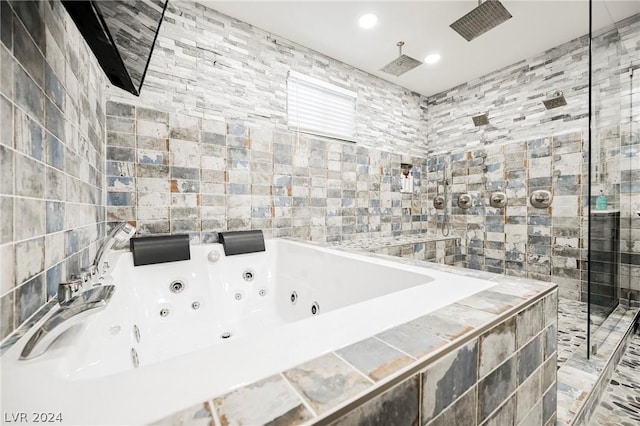 bathroom featuring tile walls and shower with separate bathtub