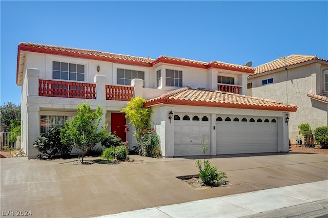 mediterranean / spanish home with a garage and a balcony