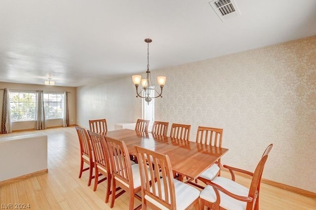 dining area with a chandelier and light hardwood / wood-style floors