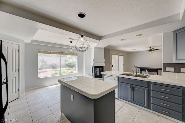 kitchen featuring a center island, sink, a multi sided fireplace, white dishwasher, and gray cabinets