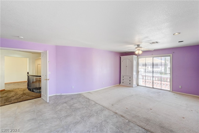 carpeted empty room featuring a textured ceiling and ceiling fan