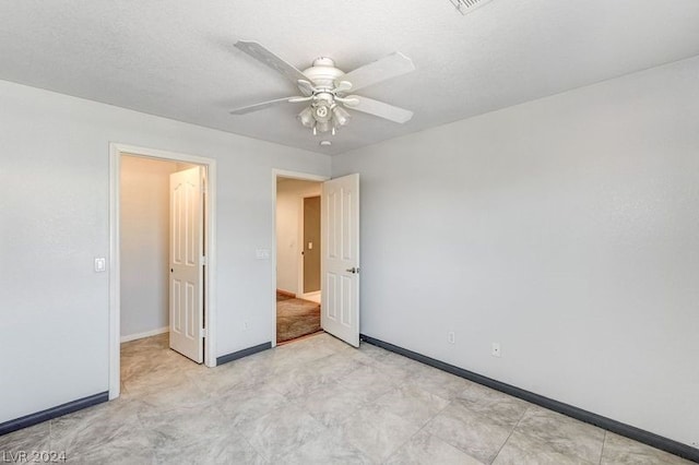 unfurnished bedroom featuring ceiling fan and a textured ceiling