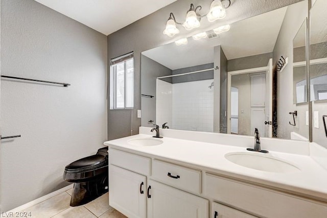 bathroom featuring tile patterned flooring, vanity, toilet, and a shower