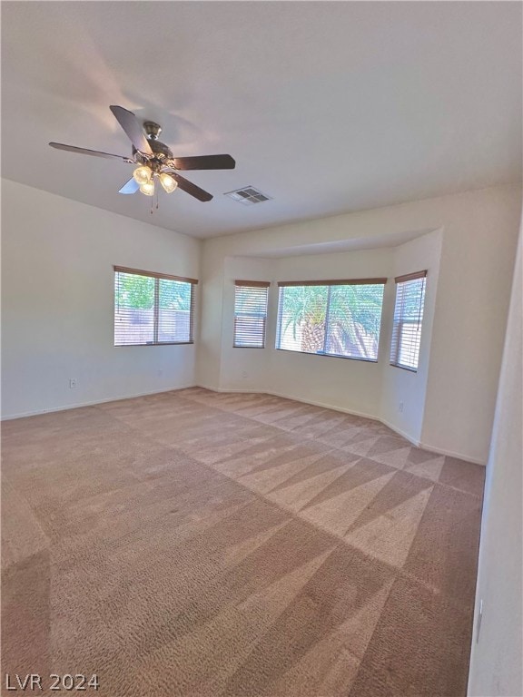 carpeted spare room with ceiling fan