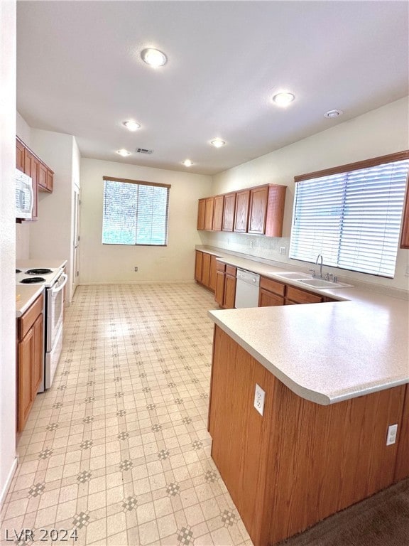 kitchen featuring sink, white appliances, and light tile floors