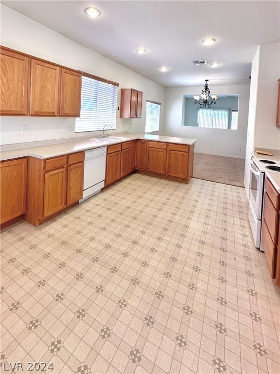 kitchen featuring kitchen peninsula, white appliances, light carpet, a notable chandelier, and sink