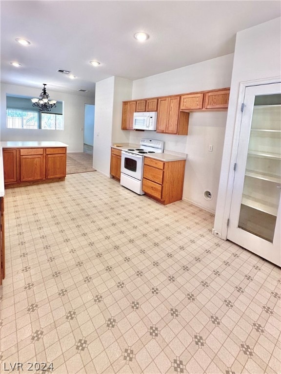 kitchen featuring white appliances, light tile flooring, and a chandelier