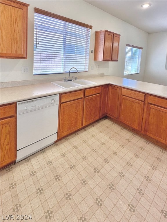 kitchen with dishwasher, sink, and light tile floors