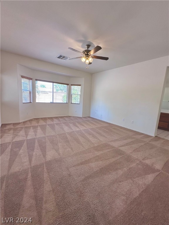 carpeted empty room featuring ceiling fan