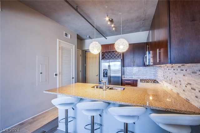 kitchen featuring light stone countertops, stainless steel appliances, tasteful backsplash, and sink