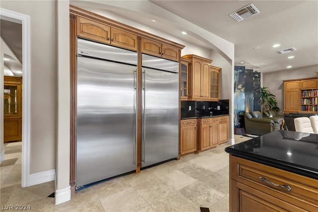 kitchen with decorative backsplash, light tile patterned flooring, and stainless steel built in refrigerator