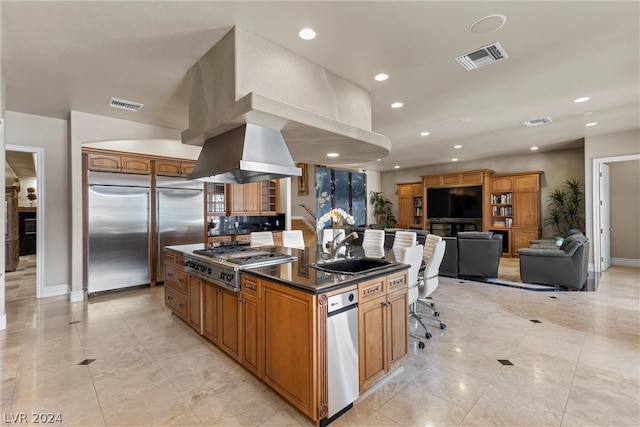 kitchen with a kitchen bar, appliances with stainless steel finishes, sink, backsplash, and a center island