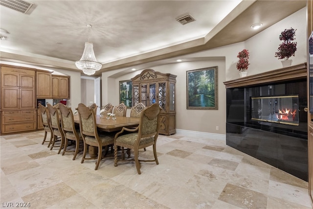 tiled dining space with a raised ceiling and a notable chandelier