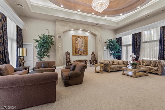 living room with carpet floors, a chandelier, and a raised ceiling