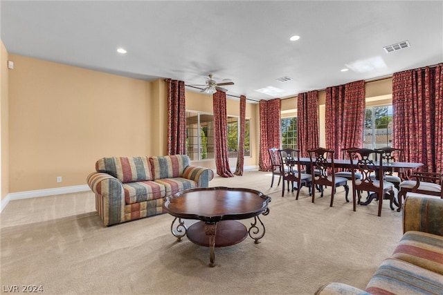 carpeted living room with ceiling fan