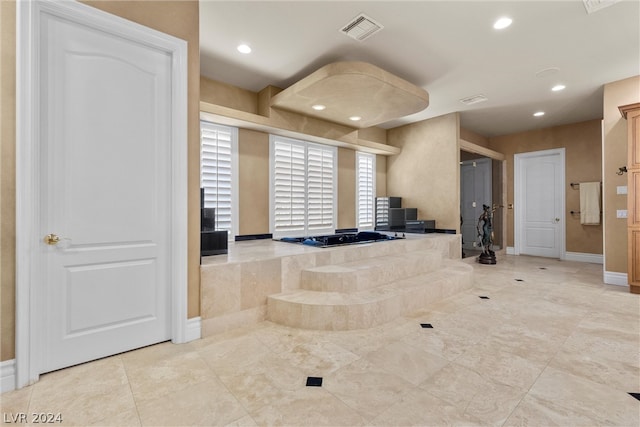 bathroom featuring tiled tub and tile patterned flooring