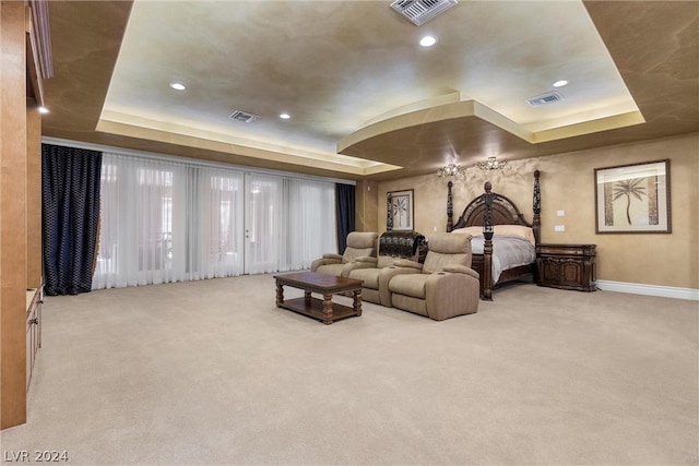 carpeted bedroom with a tray ceiling