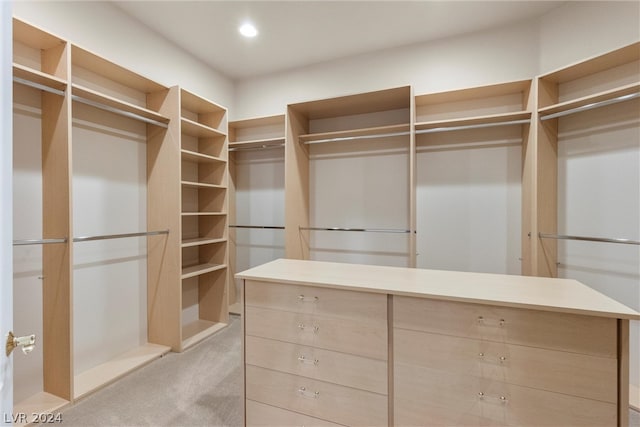 walk in closet featuring light colored carpet