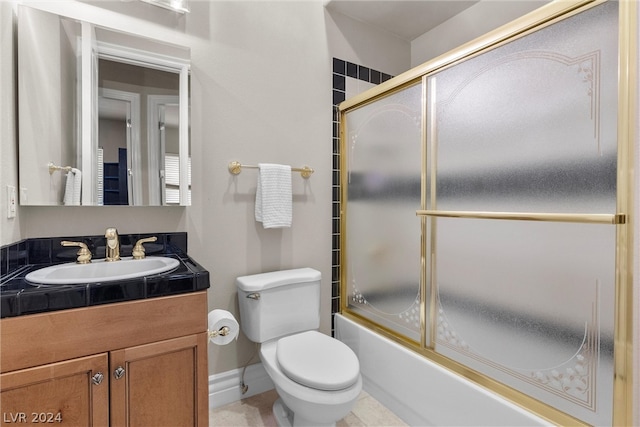 full bathroom with shower / bath combination with glass door, vanity, tile patterned flooring, and toilet