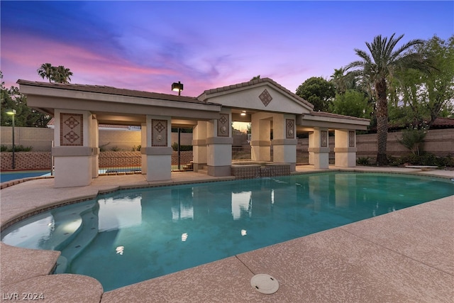 pool at dusk featuring a patio area