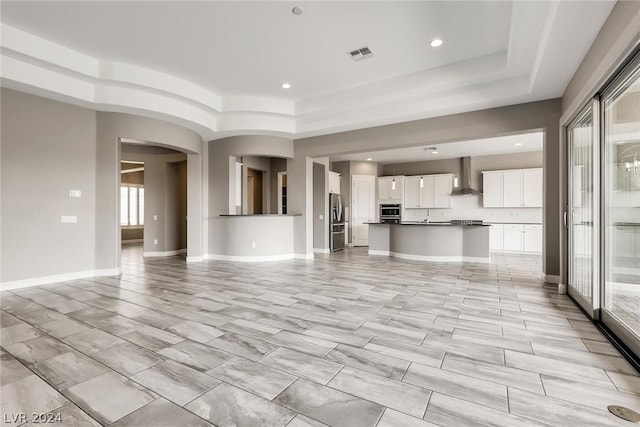 unfurnished living room with a tray ceiling