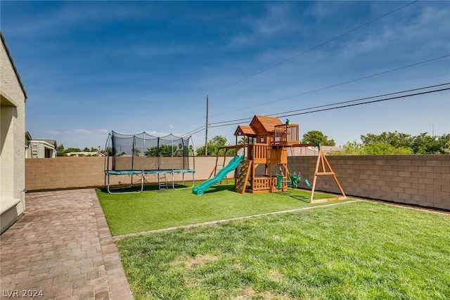 view of playground featuring a trampoline and a lawn